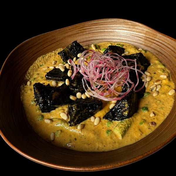 Blackened fish in a yellow curry sauce with pine nuts and pickled red onions.